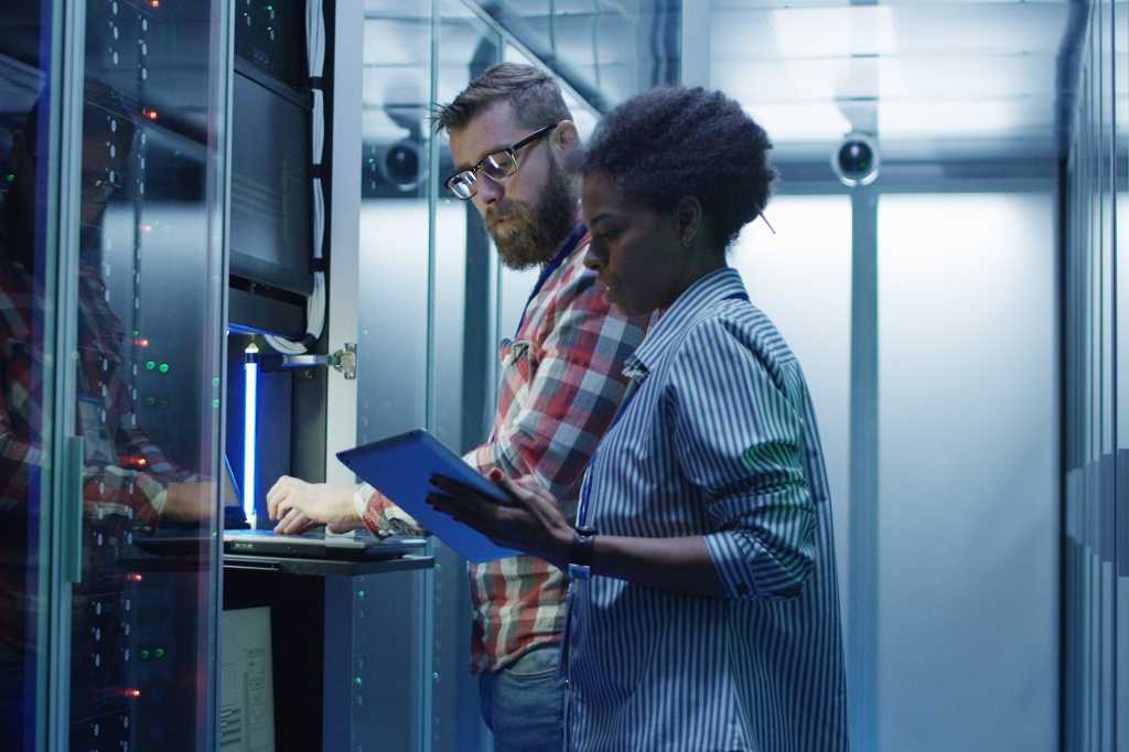 IT staff setting server hardware in a data center.