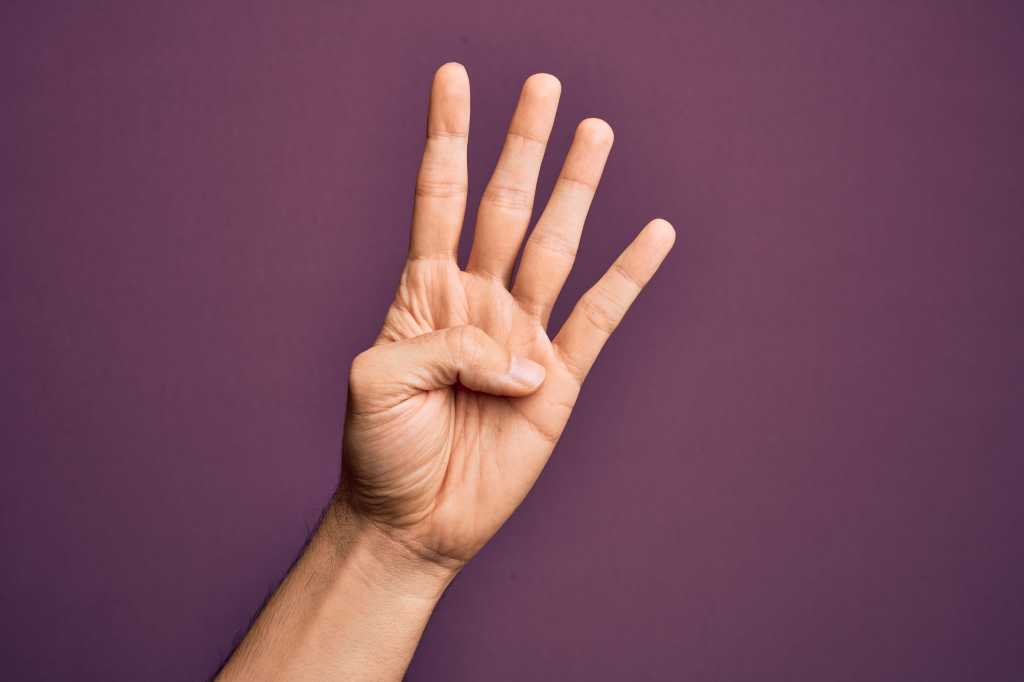 Caucasian hand holding up four fingers. Number 4.