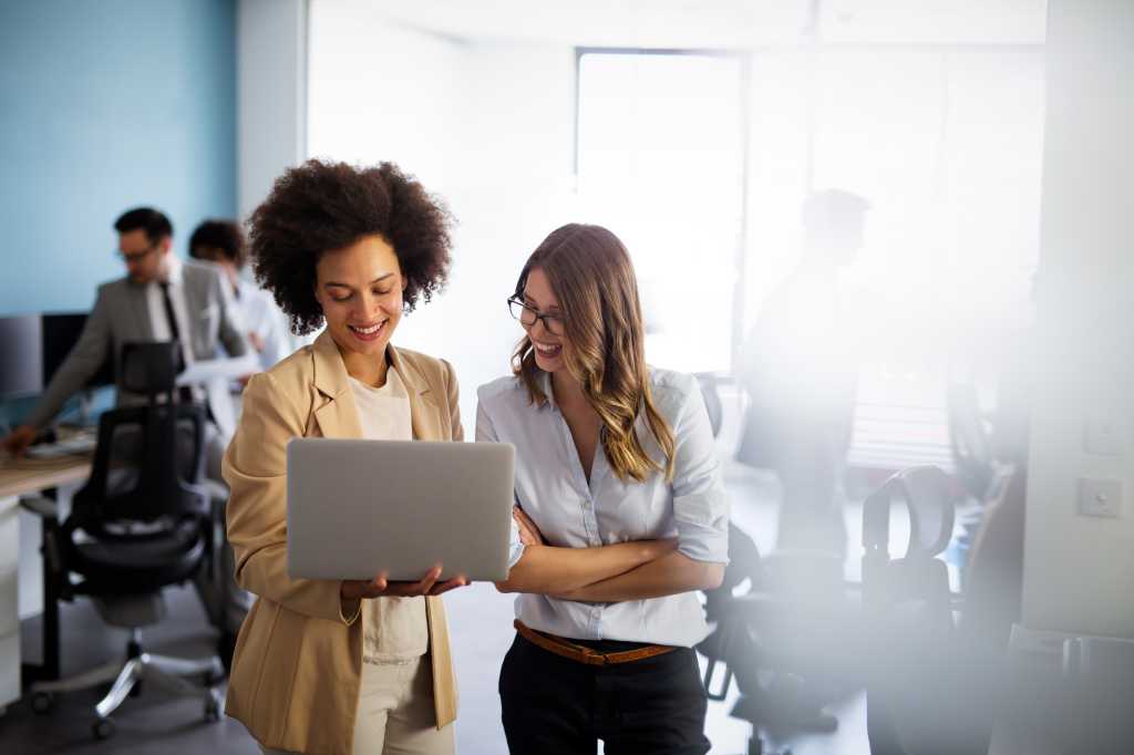 Happy multiethnic smiling business women working together in office